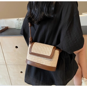 Detail of straw crossbody bag with leather trim and Fashion & BaG EST.1985 text
