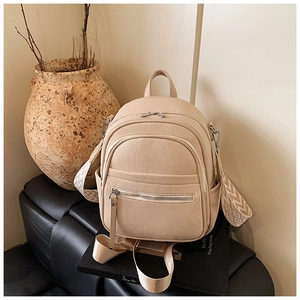 Detail of beige woven backpack featuring ethnic geometric pattern straps and silver hardware