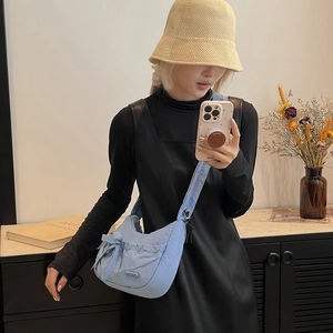 Mirror selfie showing light blue nylon hobo bag with bow detail and ruched design