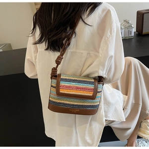 Detail of colorful woven straw bag with leather trim and stylish knotted shoulder strap