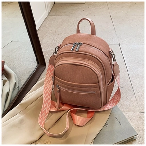 Close-up of pink mini backpack featuring canvas texture and geometric patterned strap