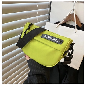Close-up of vibrant neon green nylon saddle bag with wide strap and fashion brand tag