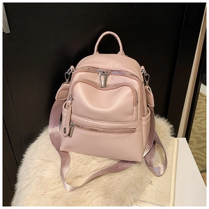 Detail view of pink faux leather multi-pocket backpack with wide textile straps