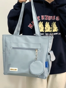 Close-up of light blue nylon tote bag with side pocket and small round coin purse