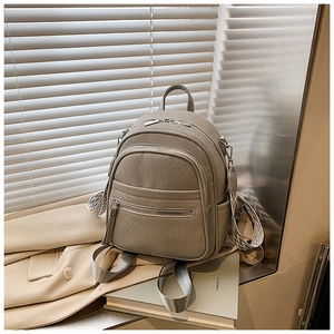 Close-up of woven mini backpack with multi-zipper and geometric patterned strap