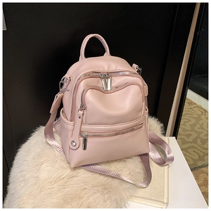 Detail view of pink PU leather backpack with three front zippers and silver hardware