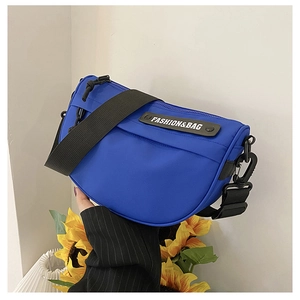 Detail of bright blue nylon saddle bag featuring a wide adjustable strap and zipper