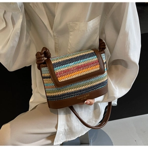 Detail of multi-color striped straw crossbody bag with brown leather flap and knotted strap