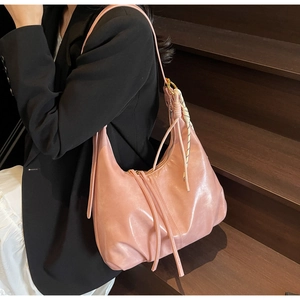 Sac hobo demi-lune en cuir PU rose avec foulard en soie porté par un mannequin en scène