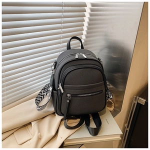 Detail of dark grey multi-zipper backpack with geometric pattern woven shoulder strap