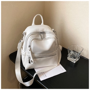 Close-up of white mini backpack with lychee grain texture and silver zip details