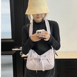 Lavender nylon tote bag with bow detail and drawstring pleats shown on shoulder