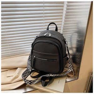 Detail of grey woven backpack with geometric strap and functional multi-pocket layout