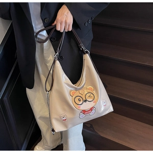 Detail of hobo tote bag featuring cute cartoon bear print and shiny metallic chain