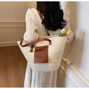 Détail du sac cabas tissé avec anses en cuir et poche avant pour les vacances d'été