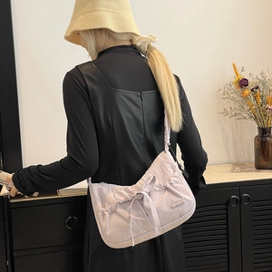 Detail of lilac nylon tote bag with bow decoration and pleated texture on model