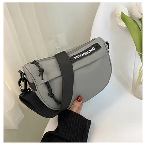 Detail of grey nylon saddle bag with black wide strap and fashion logo text