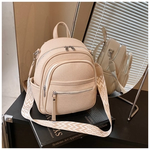 Detail of cream mini backpack featuring woven front pocket and geometric patterned strap