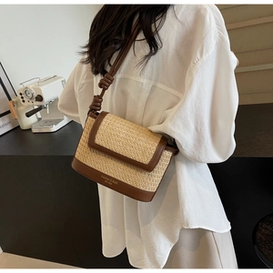 Detail of straw patchwork crossbody bag with Fashion & BaG text and knotted shoulder strap