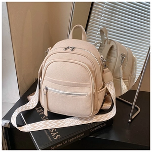 Close-up of beige backpack featuring woven texture and geometric patterned wide strap