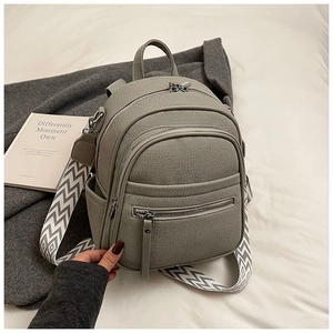 Detail view of a gray mini backpack with stylish geometric patterned wide shoulder strap