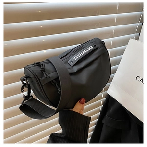 Detail of black nylon saddle bag with a wide strap and Fashion & Bag woven label