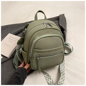 Detail of olive green canvas backpack with geometric patterned strap and multiple zipper pockets