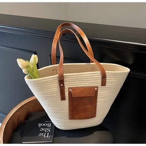 Détail d'un sac cabas tissé avec texture en spirale crème et poche en similicuir brun