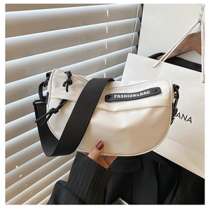 Detail of white nylon crescent bag with wide adjustable strap and logo patch
