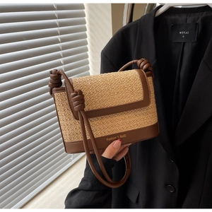 Detail of straw crossbody bag with brown leather trim and knotted strap fashion texture