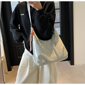 Détail du sac hobo bleu clair avec chaîne colorée et pendentifs en corde tressée