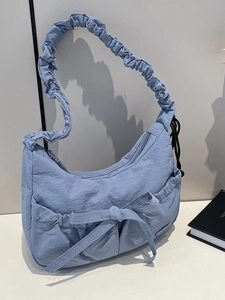 Light blue nylon hobo tote bag with a decorative bow and ruffled shoulder strap