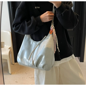 Détail d'un sac cabas en cuir PU bleu clair brillant avec un design plissé moderne