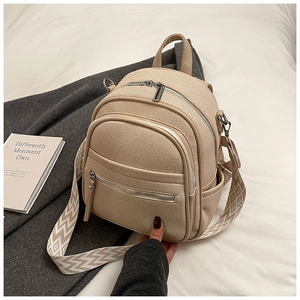 Detail of mini beige backpack featuring textured fabric and geometric patterned strap