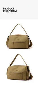 Close-up of khaki nylon duffel bag featuring durable double zippers and woven shoulder strap