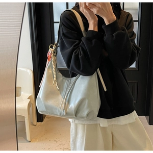 Détail du grand sac cabas bleu clair avec chaîne décorative et nœud ornemental