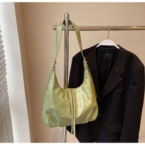 Détail du sac demi-lune vert clair avec fermeture éclair en métal et bandoulière réglable