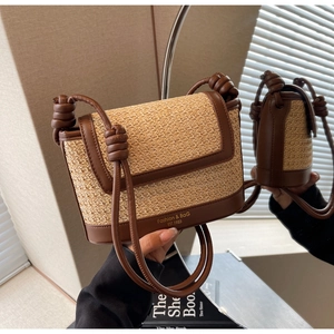 Detail of straw woven bag with brown leather trim and unique knotted shoulder strap