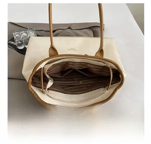Detail view of the spacious inner compartment with striped lining and zipper pocket