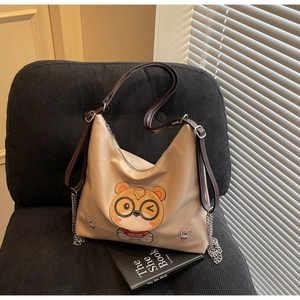 Detail of cream nylon tote bag with cartoon bear print and dark brown shoulder strap