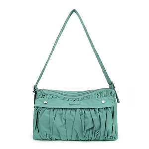 Detail of teal green pleated shoulder bag with metallic studs and adjustable strap