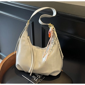 Détail du sac hobo gris montrant le similicuir souple et les breloques tressées colorées