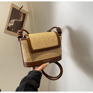 Detail of woven straw and brown leather crossbody bag with gold Fashion & Bag lettering
