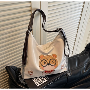 Detail of hobo tote bag featuring cartoon bear print and adjustable chain strap
