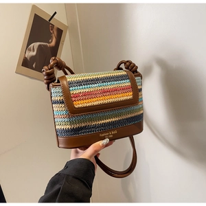 Close-up of multicolor woven straw crossbody bag with brown leather flap and knotted strap