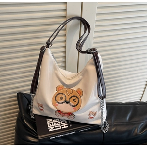 Detail of white hobo bag with cartoon bear print and silver metal chain strap link