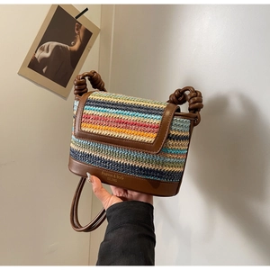 Macro shot of colorful woven straw pattern and thick knotted strap on fashion shoulder bag