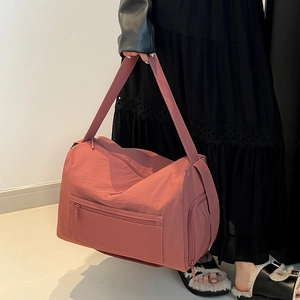 Detailansicht der rosa Nylontasche mit Seitenfach und breiten Schultergurten