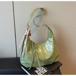 Détail du sac hobo vert clair avec texture brillante et breloque en cordelette tissée