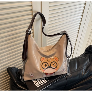 Detailed view of beige tote bag featuring cute cartoon hamster print and metal chain
